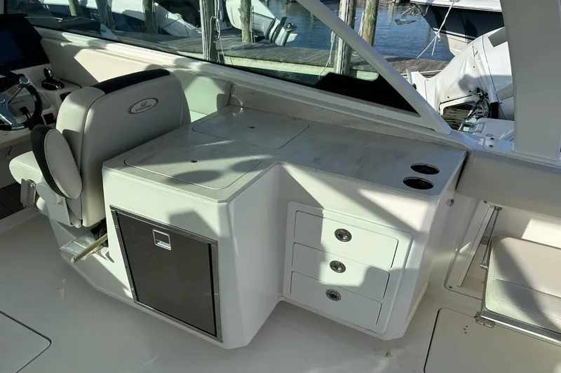  Yacht Photos Pics 2023 Sailfish 316 DC boat interior with helm seat, storage drawers, and cup holders.