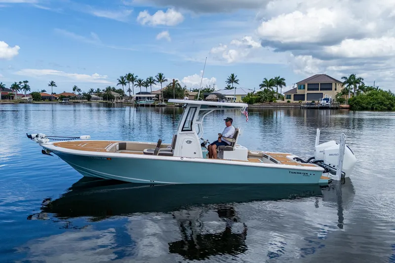  Yacht Photos Pics 2023 Tidewater 2700 Carolina Bay boat on calm water, with a person at the helm.
