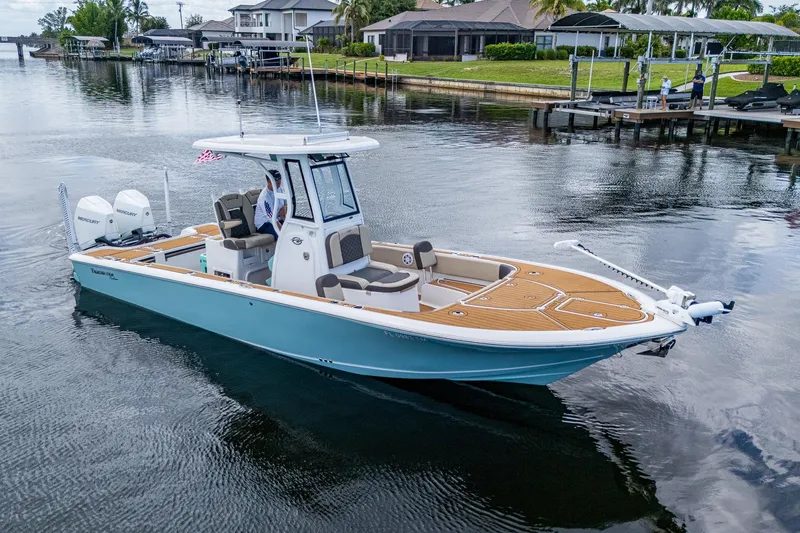  Yacht Photos Pics 2023 Tidewater 2700 Carolina Bay boat on calm water near residential docks.