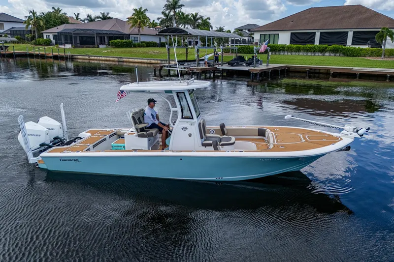  Yacht Photos Pics 2023 Tidewater 2700 Carolina Bay boat on calm water near residential docks.