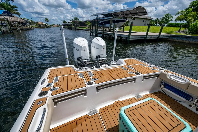  Yacht Photos Pics 2023 Tidewater 2700 Carolina Bay boat with dual Mercury engines on a sunny waterway.