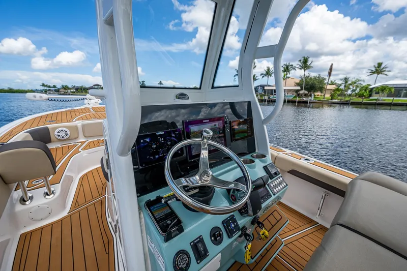  Yacht Photos Pics 2023 Tidewater 2700 Carolina Bay boat interior with modern dashboard and scenic water view.