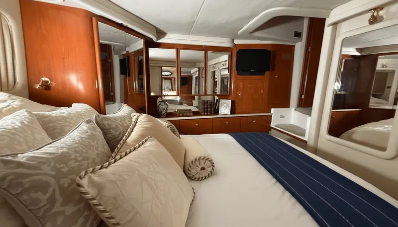 Optics Yacht Photos Pics Luxurious 1999 Sea Ray 420 Aft Cabin interior with elegant bedding and wood cabinetry.