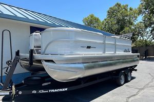 2026 Sun Tracker Party Barge 20 DLX pontoon boat on trailer, parked outdoors.