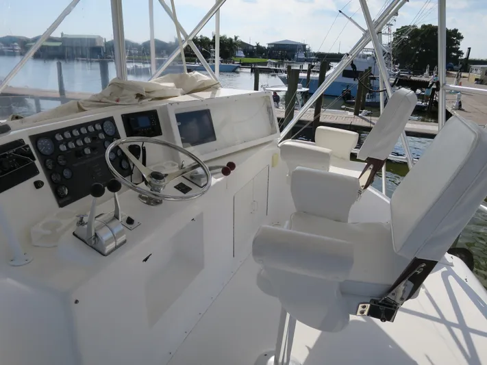 High Risk Yacht Photos Pics 1997 Post 50 Flybridge helm with dual captain chairs and control panel.