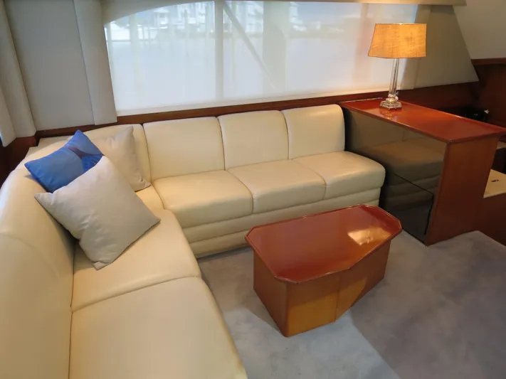 High Risk Yacht Photos Pics Luxurious 1997 Post 50 Flybridge yacht interior with cream leather sofa and wooden table.
