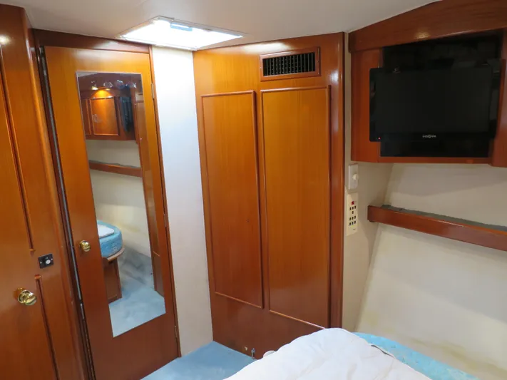 High Risk Yacht Photos Pics 1997 Post 50 Flybridge yacht interior with wooden cabinets and mounted TV.