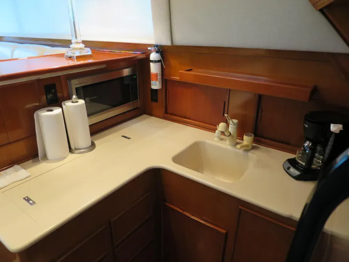 High Risk Yacht Photos Pics 1997 Post 50 Flybridge yacht kitchen with sink, microwave, and coffee maker.