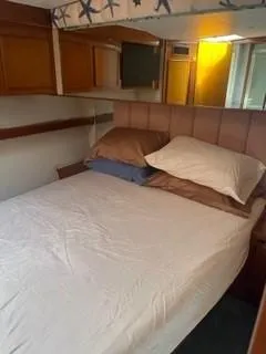 High Risk Yacht Photos Pics 1997 Post 50 Flybridge cabin with bed and wooden storage cabinets.