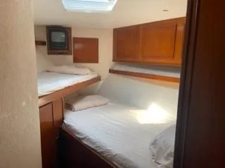 High Risk Yacht Photos Pics 1997 Post 50 Flybridge cabin with twin beds and wooden cabinets.