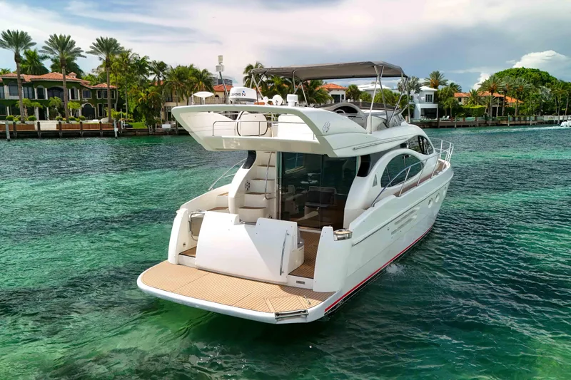  Yacht Photos Pics 2001 Azimut 46 yacht cruising on clear turquoise waters near luxury waterfront homes.