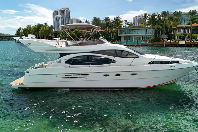  Yacht Photos Pics 2001 Azimut 46 yacht cruising on clear turquoise water near luxury waterfront homes.