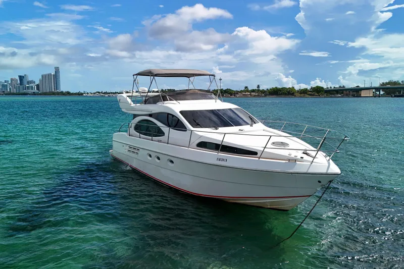  Yacht Photos Pics 2001 Azimut 46 yacht on turquoise water with city skyline in background.