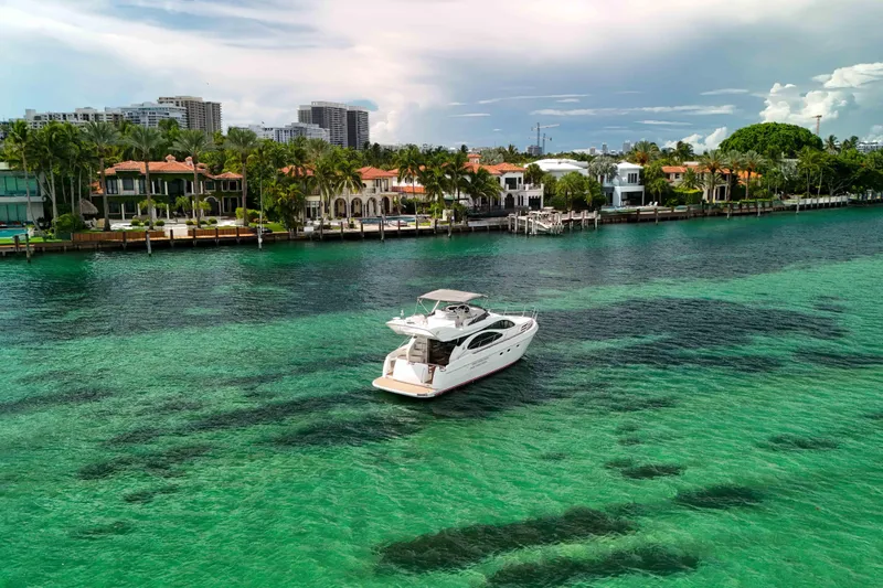  Yacht Photos Pics Luxury 2001 Azimut 46 yacht cruising on turquoise waters near waterfront homes.