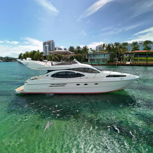  Yacht Photos Pics 2001 Azimut 46 yacht cruising on clear turquoise water near luxury waterfront homes.