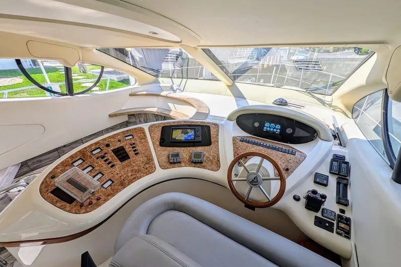  Yacht Photos Pics Luxurious 2001 Azimut 46 yacht cockpit with modern navigation controls and wooden steering wheel.