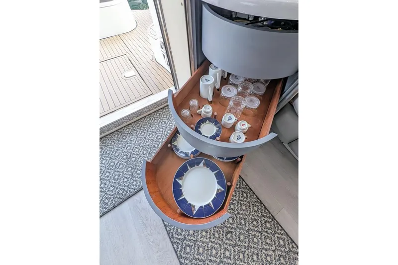  Yacht Photos Pics Interior of 2001 Azimut 46 yacht with open drawer displaying elegant dishware and glasses.