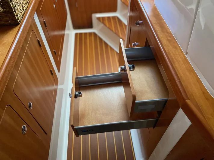 Magic Yacht Photos Pics Wooden cabinetry with open drawers in a 2008 PDQ MV-41 boat interior.