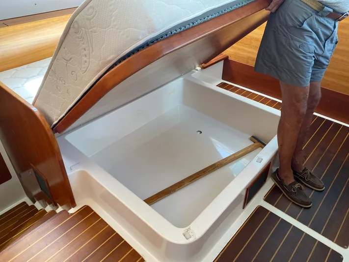 Magic Yacht Photos Pics Man opening storage compartment on 2008 PDQ MV-41 boat with wooden flooring.