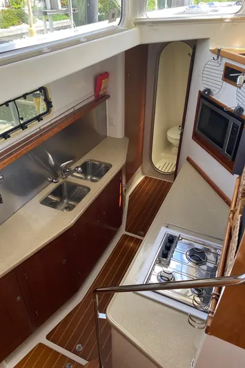 Magic Yacht Photos Pics Compact kitchen area in a 2008 PDQ MV-41 boat with sink, stove, and microwave.
