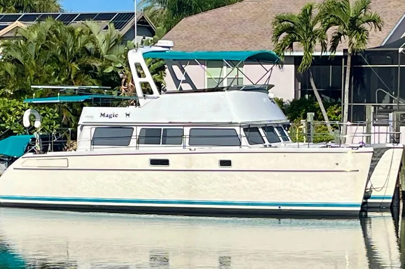 Magic Yacht Photos Pics 2008 PDQ MV-41 boat docked near tropical foliage and residential area.