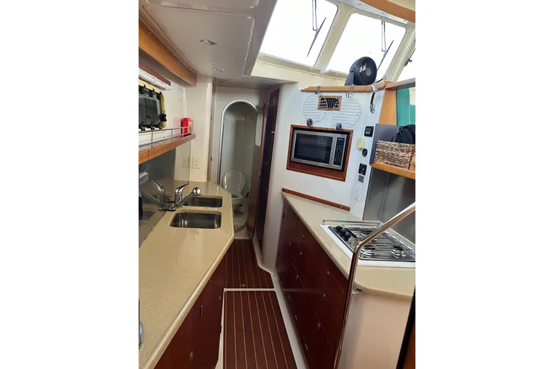 Magic Yacht Photos Pics Interior of 2008 PDQ MV-41 yacht kitchen with modern appliances and wood accents.