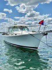 Fin & Tonic Yacht Photos Pics 2020 Back Cove 34O boat on water under cloudy sky.