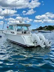 Fin & Tonic Yacht Photos Pics 2020 Back Cove 34O boat on water under blue sky with clouds.