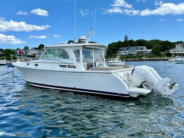 Fin & Tonic Yacht Photos Pics 2020 Back Cove 34O boat on water, clear sky, coastal background.