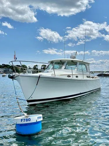 Fin & Tonic Yacht Photos Pics 2020 Back Cove 34O boat on water, clear sky, moored near buoy.