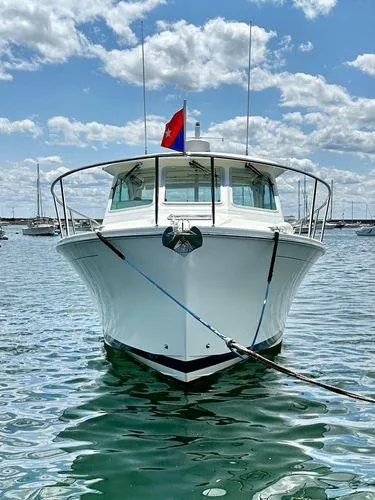 Fin & Tonic Yacht Photos Pics 2020 Back Cove 34O boat on water, front view, with blue sky and clouds.
