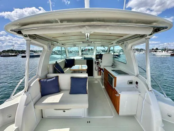 Fin & Tonic Yacht Photos Pics 2020 Back Cove 34O boat interior with seating, table, and helm on a sunny day.