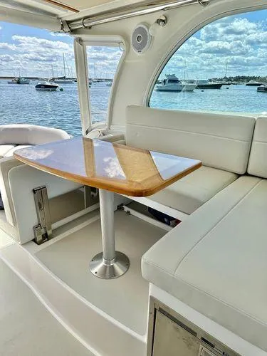 Fin & Tonic Yacht Photos Pics 2020 Back Cove 34O interior with elegant seating and table, overlooking a serene marina.