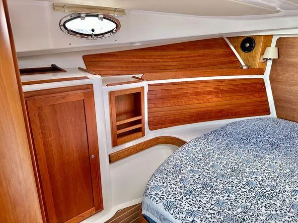 Fin & Tonic Yacht Photos Pics 2020 Back Cove 34O cabin interior with wooden paneling and cozy bed.