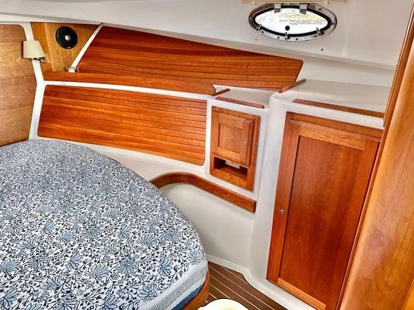 Fin & Tonic Yacht Photos Pics 2020 Back Cove 34O cabin with wood paneling and patterned bedding.