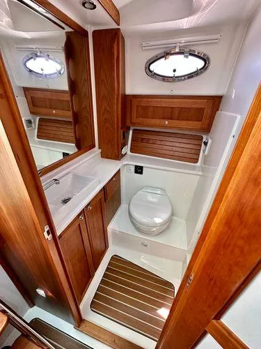 Fin & Tonic Yacht Photos Pics 2020 Back Cove 34O yacht bathroom with wooden cabinetry and modern fixtures.
