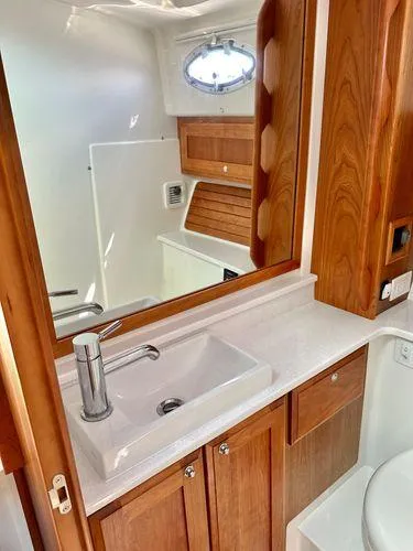 Fin & Tonic Yacht Photos Pics 2020 Back Cove 34O yacht bathroom with wooden cabinetry and modern sink.