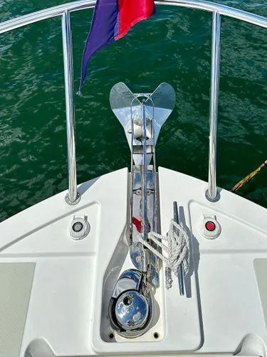 Fin & Tonic Yacht Photos Pics 2020 Back Cove 34O boat bow with anchor and flag on water.