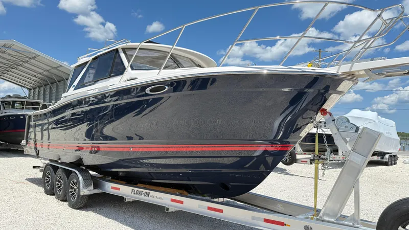  Yacht Photos Pics 2026 Cutwater C-288 Coupe boat on trailer under blue sky.