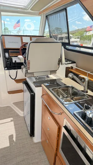  Yacht Photos Pics Interior of 2026 Cutwater C-288 Coupe featuring helm, kitchen sink, and appliances.