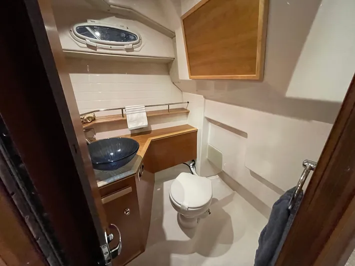  Yacht Photos Pics 2026 Cutwater C-288 Coupe bathroom with modern sink, toilet, and wooden cabinetry.
