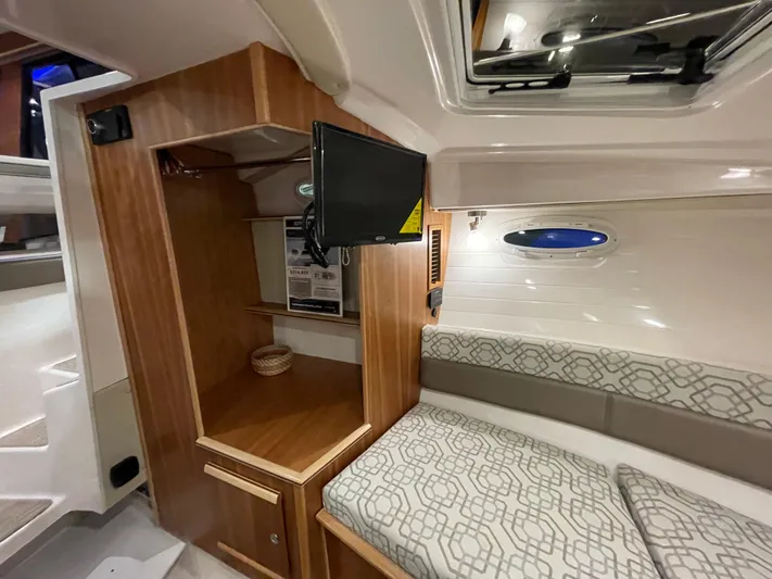  Yacht Photos Pics 2026 Cutwater C-288 Coupe interior with wood cabinetry, TV, and patterned seating.