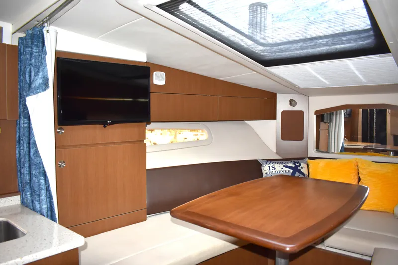  Yacht Photos Pics Interior of 2016 Sea Ray 310 Sundancer yacht with modern wood finish and cozy seating area.