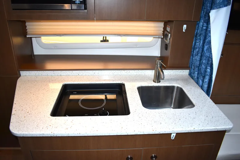  Yacht Photos Pics 2016 Sea Ray 310 Sundancer galley with stove, sink, and modern countertop.
