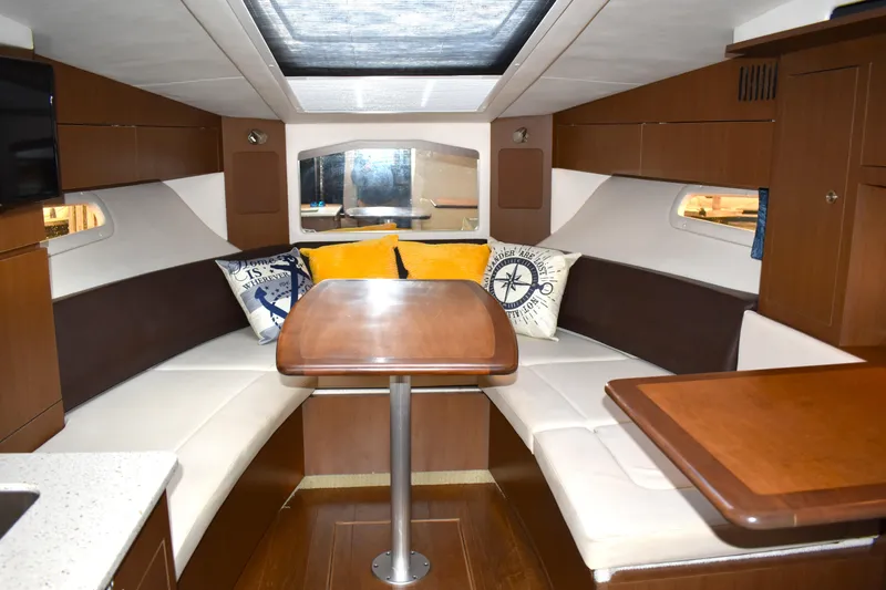  Yacht Photos Pics 2016 Sea Ray 310 Sundancer cabin with cozy seating and elegant wooden table.