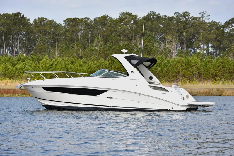  Yacht Photos Pics 2016 Sea Ray 310 Sundancer cruising on a calm lake with forested background.