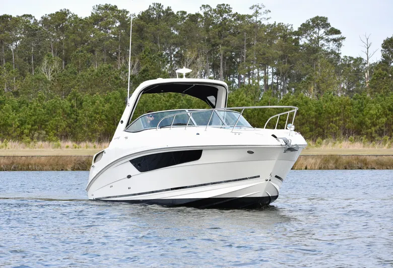  Yacht Photos Pics 2016 Sea Ray 310 Sundancer cruising on a calm lake with forested background.