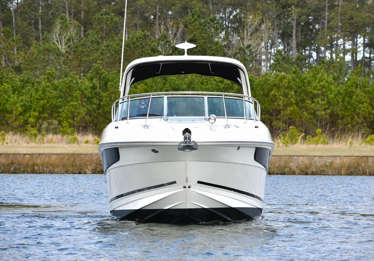  Yacht Photos Pics 2016 Sea Ray 310 Sundancer boat on water, front view, with forest background.