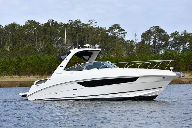  Yacht Photos Pics 2016 Sea Ray 310 Sundancer cruising on a calm lake with forested background.