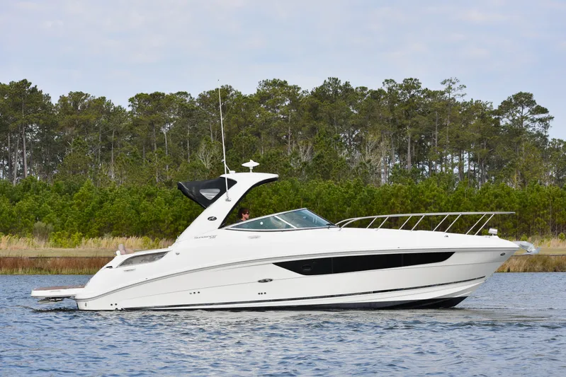  Yacht Photos Pics 2016 Sea Ray 310 Sundancer cruising on a calm lake with forested background.